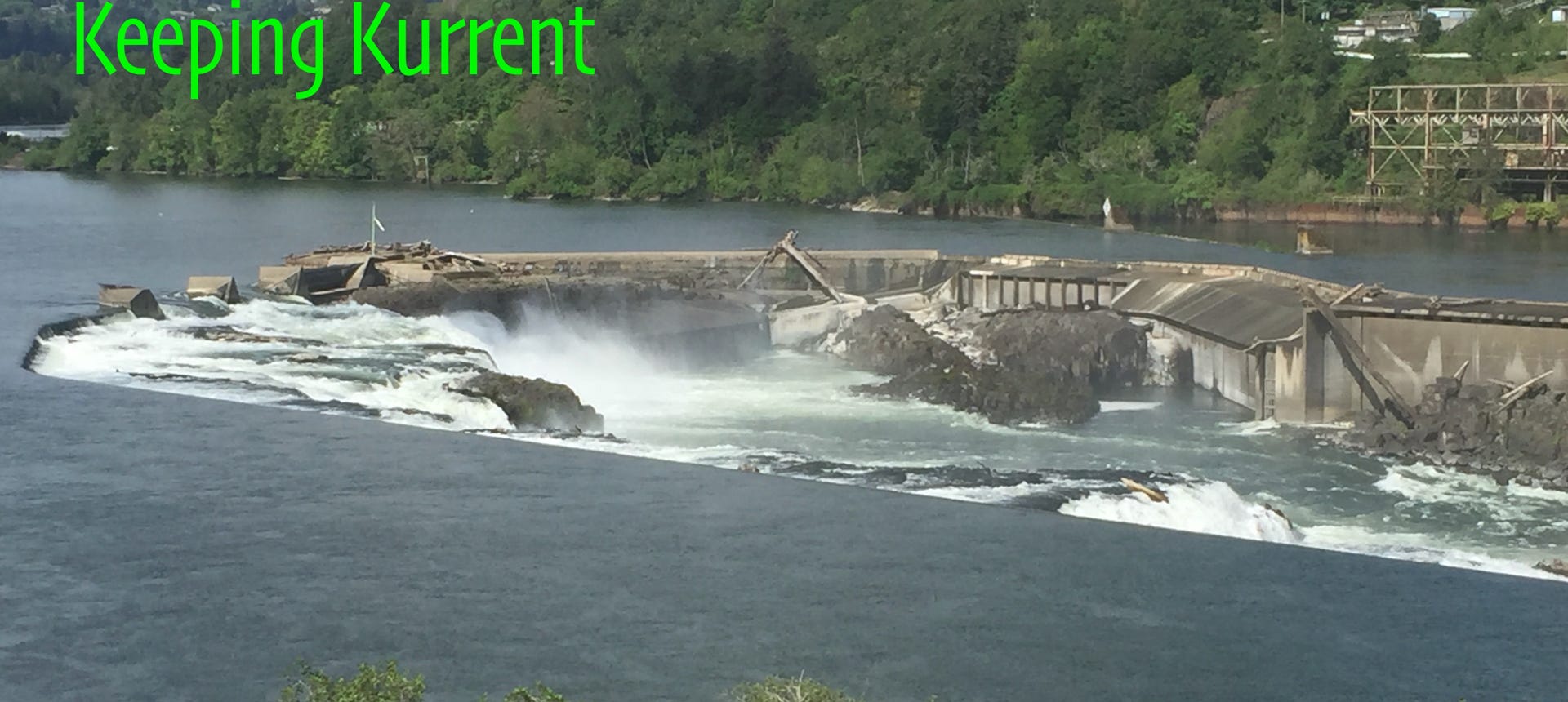 Water streaming over Willamette Falls by old paper mill.